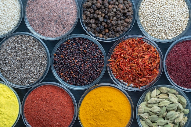 Variedade de sementes de especiarias coloridas e ervas para cozinhar comida vista superior