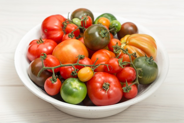 Variedade de tomates frescos em uma tigela de madeira