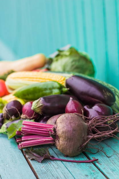 Variedade de vegetais frescos da fazenda orgânica em um fundo de madeira pintado de azul. conceito de mercado de estilo country, produtos de jardinagem locais, dieta alimentar limpa