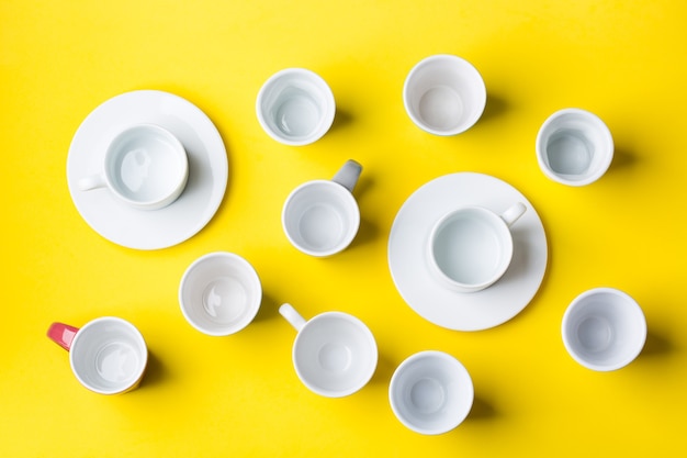 Foto variedade de xícaras de café e canecas com um fundo amarelo. criativo na moda plana lay