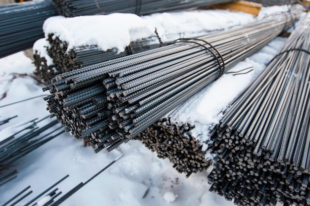 Foto las varillas de metal están empacadas en el suelo nevado