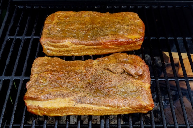 Varios ahumados a la parrilla tocino de barbacoa cocinado en la parrilla de humo, de cerca