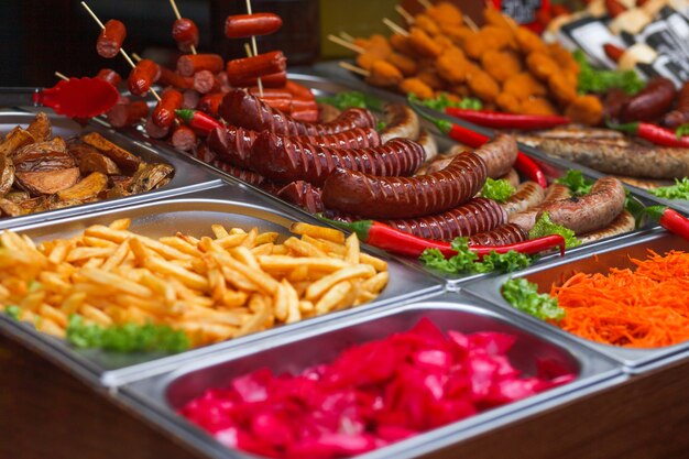 Vários alimentos na feira anual de natal. salsichas fritas, batatas fritas e outros alimentos saborosos