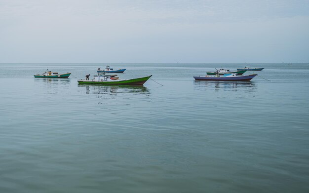 Varios barcos de pesca están anclados cerca del muelle por la mañana