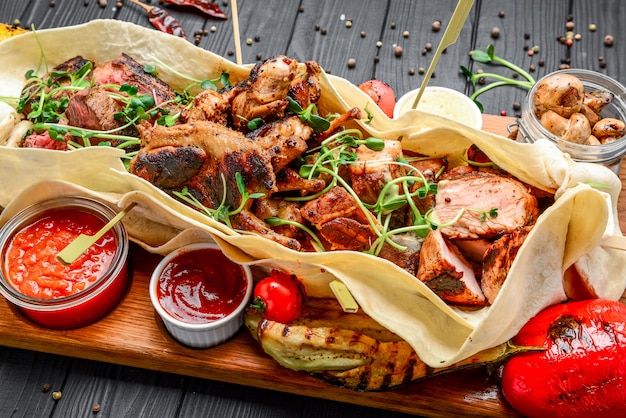 Varios bocadillos de carne a la parrilla fritos con varias salsas