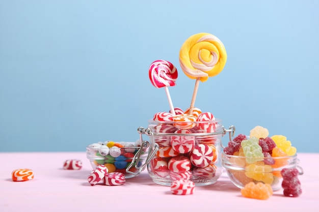 Varios caramelos y dulces en la mesa sobre un fondo de color