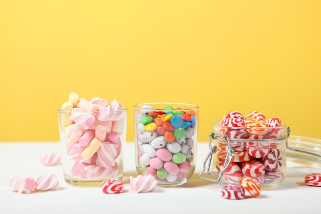 Foto varios caramelos y dulces en la mesa sobre un fondo de color