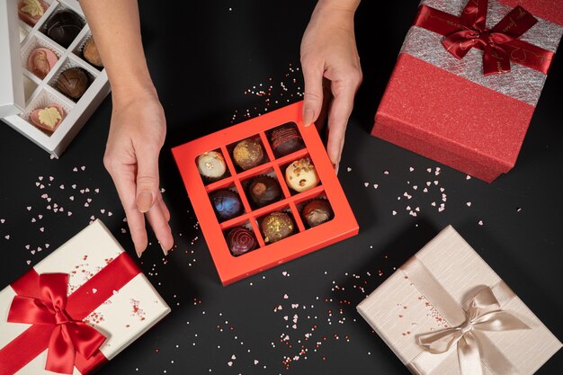 Varios caramelos de trufa de chocolate en una caja sobre fondo de piedra gris