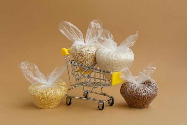 Varios cereales en paquetes en el carro de la compra. Arroz y avena, trigo sarraceno y mijo