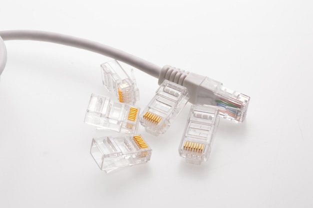 Varios conectores rg 45 para cables de internet yacen sobre un fondo claro Primer plano