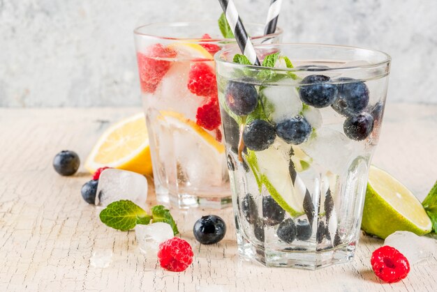 Vários coquetéis de limonada ou mojito de frutas silvestres, água com infusão de limão e framboesa