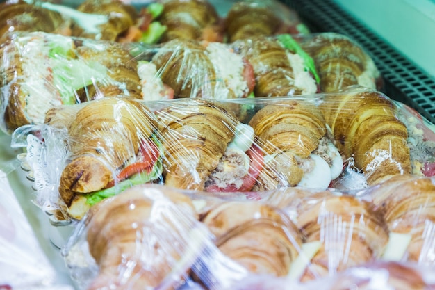 Foto vários croissants recheados com alface e tomate à venda