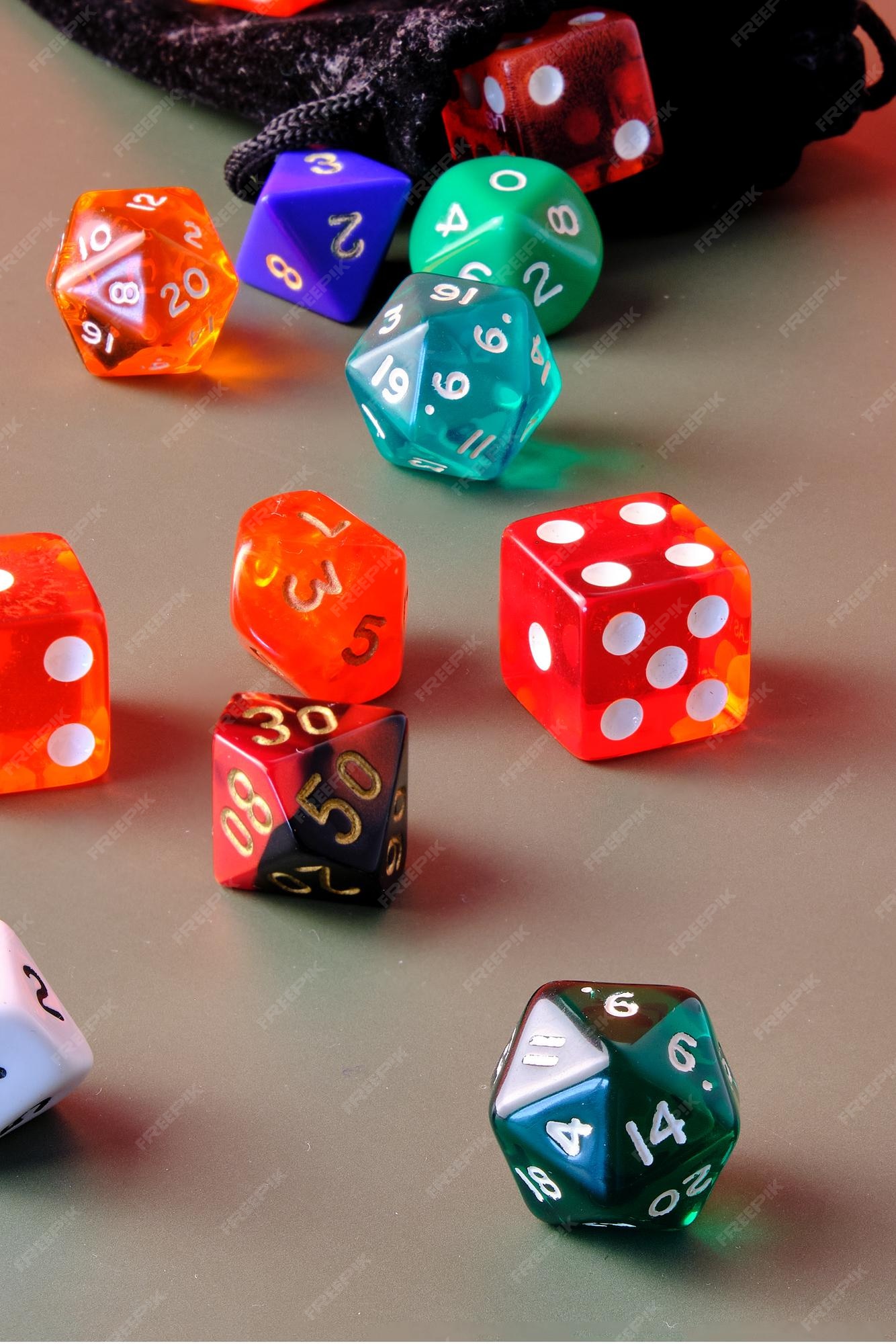 Vários dados de jogos de rpg de cores diferentes em uma mesa