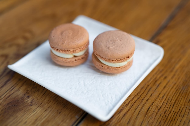 Vários deliciosos biscoitos de macaron em um suporte de prato quadrado