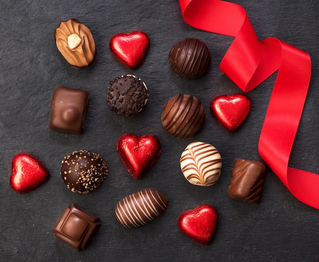 Vários doces de chocolate e uma fita vermelha