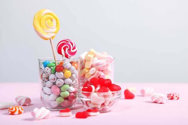 Vários doces e guloseimas na mesa em um fundo colorido