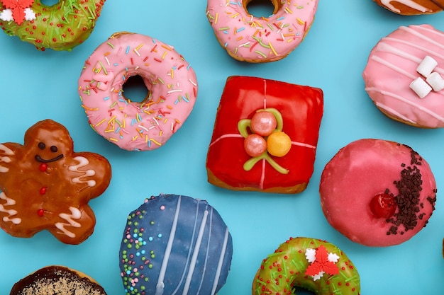 Vários donuts coloridos na superfície azul