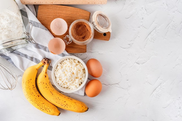 Varios ingredientes para hornear con plátano y canela sobre un fondo gris Vista superior del espacio de copia