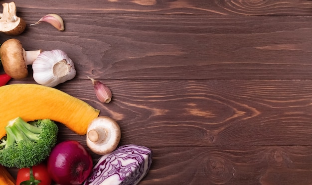 Foto varios ingredientes de verduras frescas para ensalada en madera