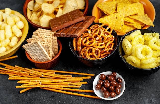 Vários lanches e chocolate em uma mesa preta