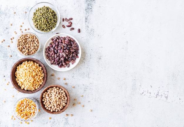 Vários legumes secos em tigelas de madeira