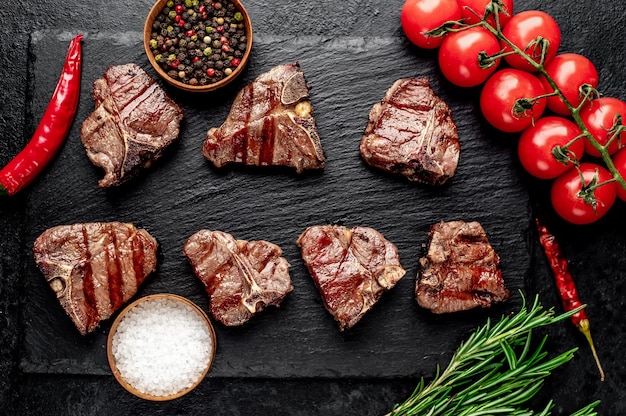 vários mini bifes grelhados T-Bone na mesa de pedra