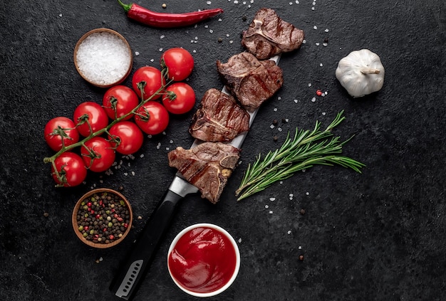 Varios mini filetes T-Bone de ternera a la parrilla en el cuchillo sobre la mesa de piedra