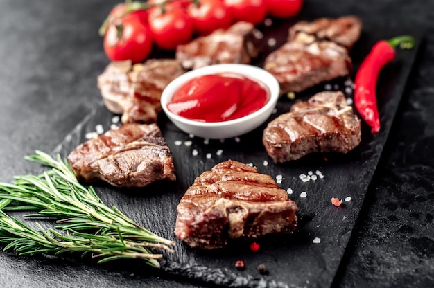 Varios mini filetes T-Bone de ternera a la parrilla sobre mesa de piedra