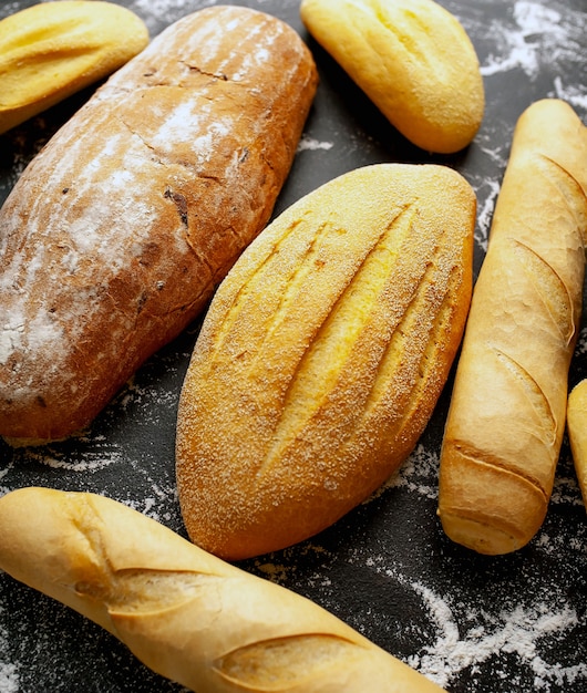 Vários pão fresco e bolos em uma mesa de pedra.