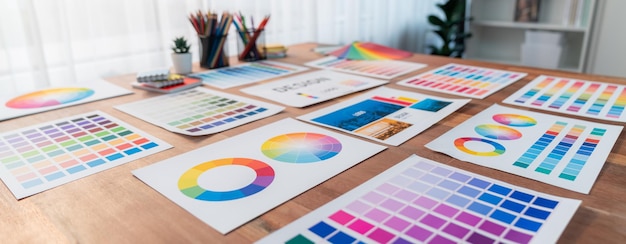 Vários papéis de ideia de paleta de cores dispostos no espaço de trabalho para o designer Scrutinize