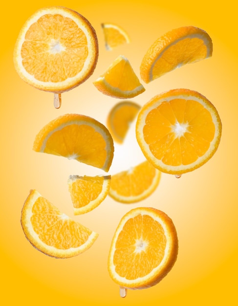 Vários pedaços de laranja levitam em uma fruta suculenta de fundo amarelo