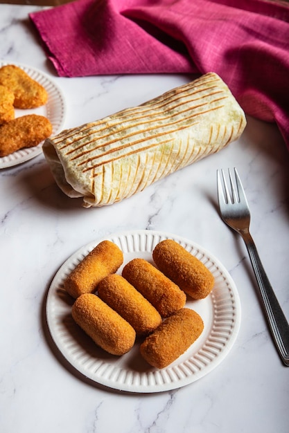 Varios platos de comida rápida en la mesa. croquetas, trigo duro y pepitas