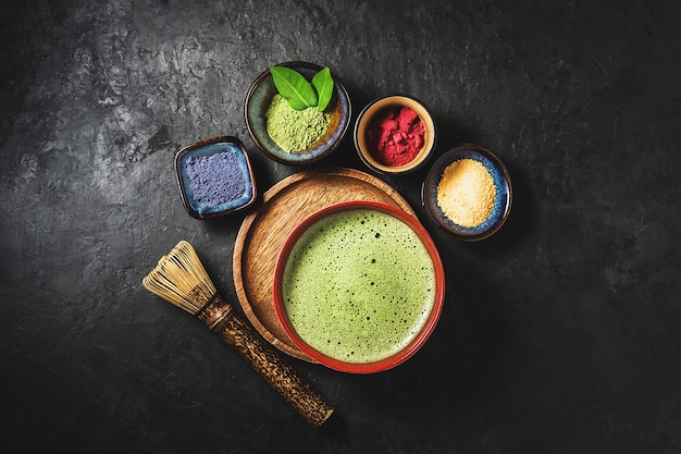 Vários pós de chá matcha em uma superfície de concreto escura. Vista do topo.