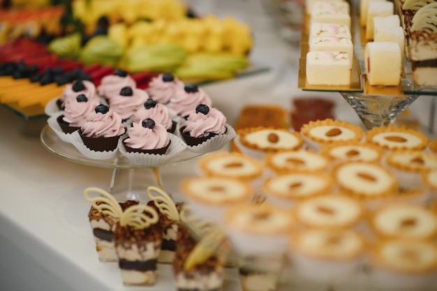 Varios postres con fruta fresca en la línea de buffet dulce