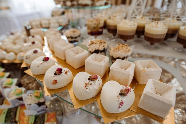 Varios postres y pasteles en la mesa de buffet de la boda