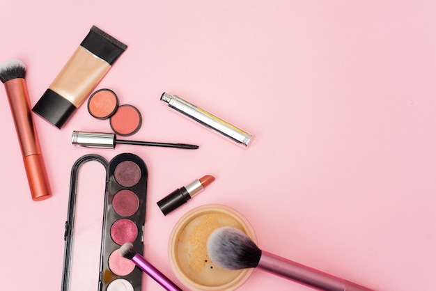 Varios productos cosméticos para maquillaje en rosa
