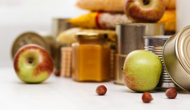 Varios productos enlatados, pastas y cereales en una mesa blanca. donación de alimentos o concepto de entrega de alimentos.