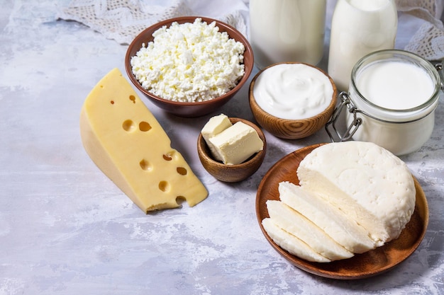 Varios productos lácteos frescos, leche, crema agria, requesón, yogur y mantequilla en una encimera de piedra clara. Copiar espacio.