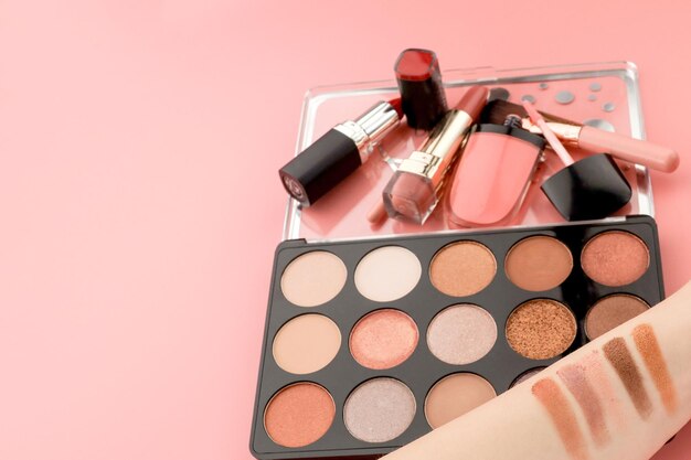Vários produtos de maquiagem em fundo rosa com copyspace