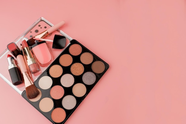 Vários produtos de maquiagem em fundo rosa com copyspace