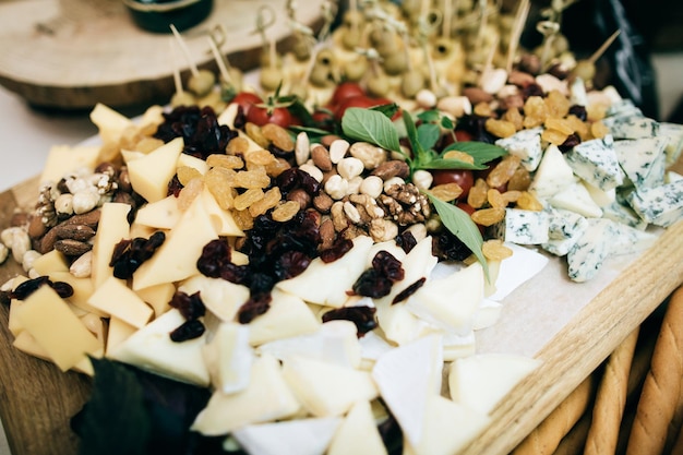 Varios quesos, frutos secos y nueces en la mesa de la boda. Aperitivos fríos para los invitados en el restaurante.