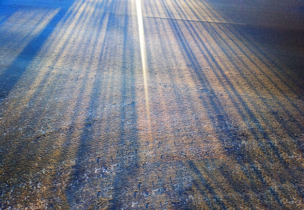 Vários raios de sol em fundo de textura de estrada de inverno