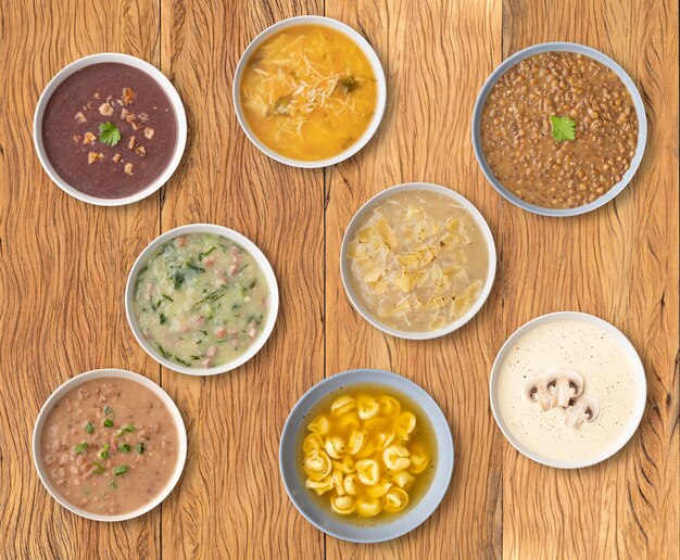 Varios sabores de sopa en tazones sobre mesa de madera