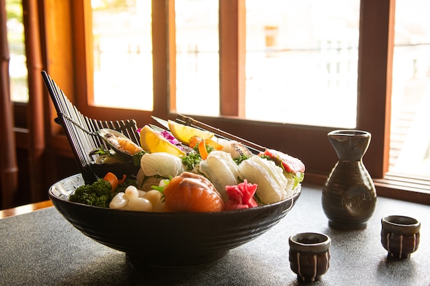Vários sashimis frescos são colocados em um prato. Chopsticks e molho de soja são colocados