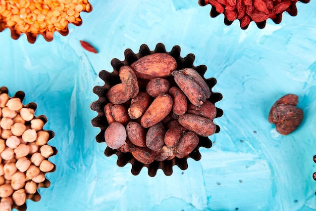 Foto vários superalimentos em uma tigela pequena no fundo azul