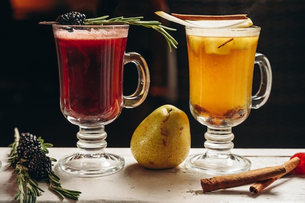 Varios té de frutas de colores cálidos o cócteles en tazas de vidrio Grog de vino caliente hot toddy punch