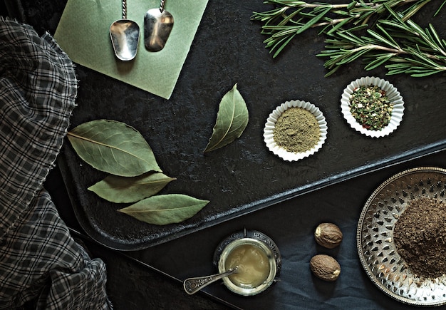 Foto vários temperos e temperos para alimentos secos em uma panela preta