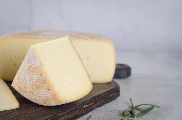 Varios tipos de cabezas y piezas de queso en una tabla de madera