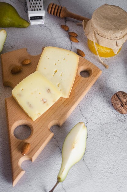 Varios tipos de cabezas y piezas de queso en una tabla de madera