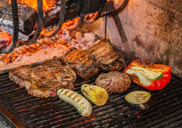Vários tipos de carne, pimentão, milho, berinjela e banana sendo assados em uma grelha